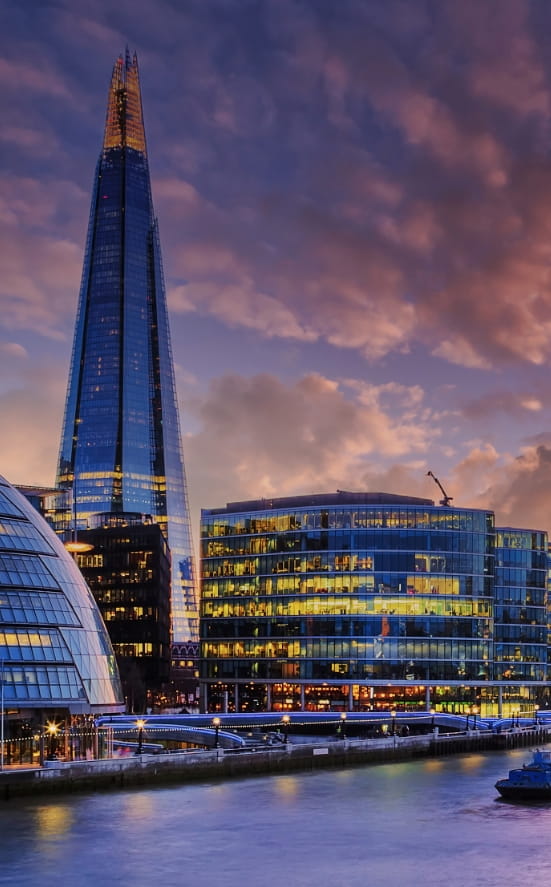 The shard in London in front of the pink and purple sunset. 