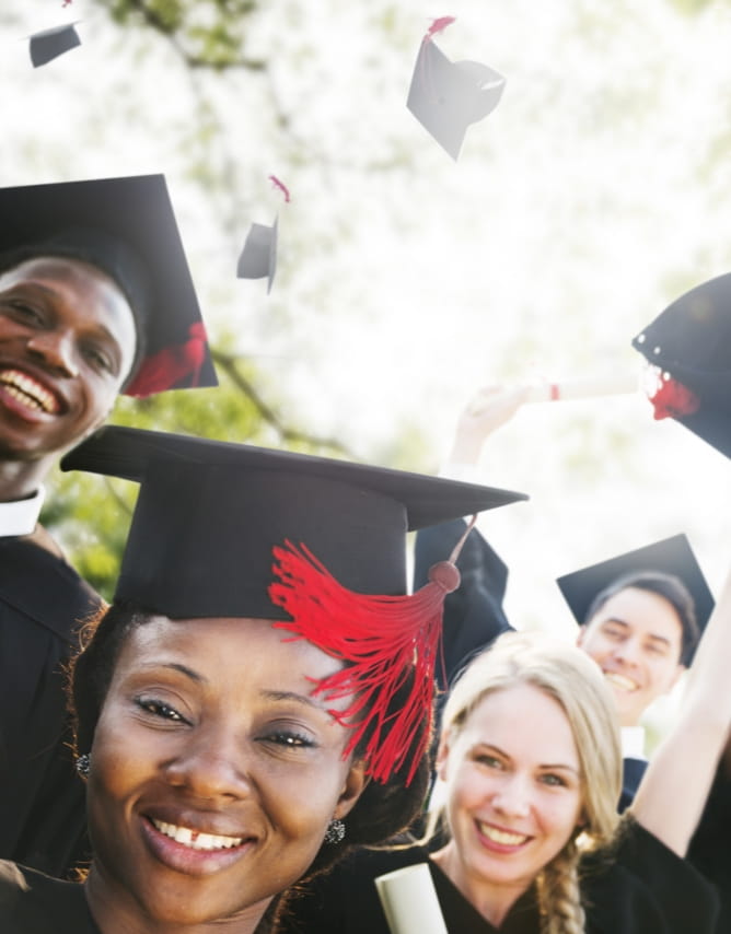 A close up of four students smiling who have just graduated from their online course. 